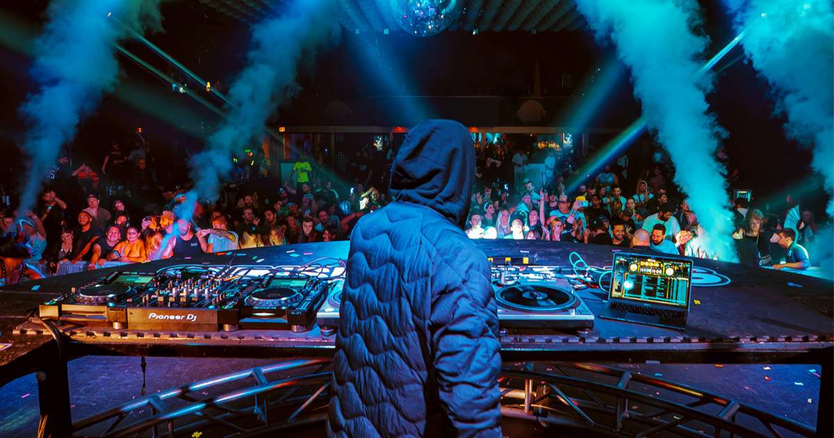 DJ UZ performing in live venue with Serato DJ Pro, top professional DJ software.