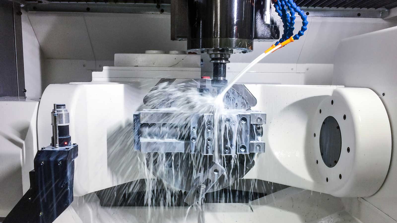 cnc machine in operation with white lubricant oil on a part