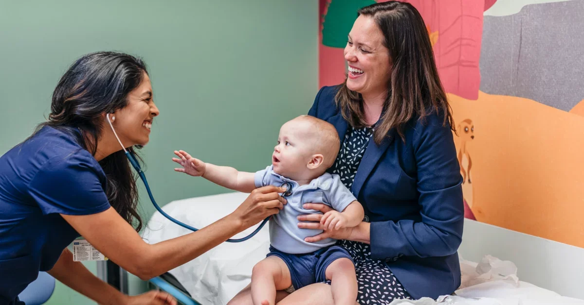 UCLA Medical School Student Doctor Providing Patient Care to Mother With Baby on Lap